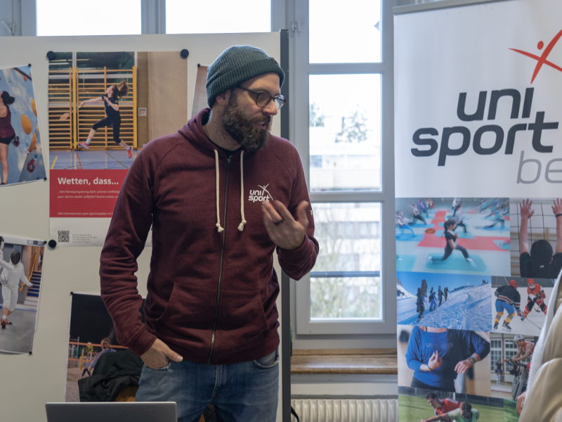 Auch der Unisport Bern ist vertreten: Christoph Wälchli stellt den Besucherinnen und Besuchern das sportliche Angebot vor. © Universität Bern, Bild: Serena Wölfel