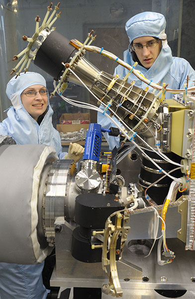 Zu sehen sind zwei Doktorandinnen, die mit dem Massenspektrometer ROSINA-DFMS Tests durchführen. Es handelt sich hierbei um das Doppel des Instruments, das an Bord der Rosetta-Sonde ist. Bild: Universität Bern