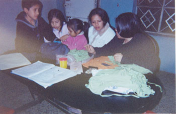 Foto einer Heimarbeiterin mit Kindern in ihrem Zuhause in Lima